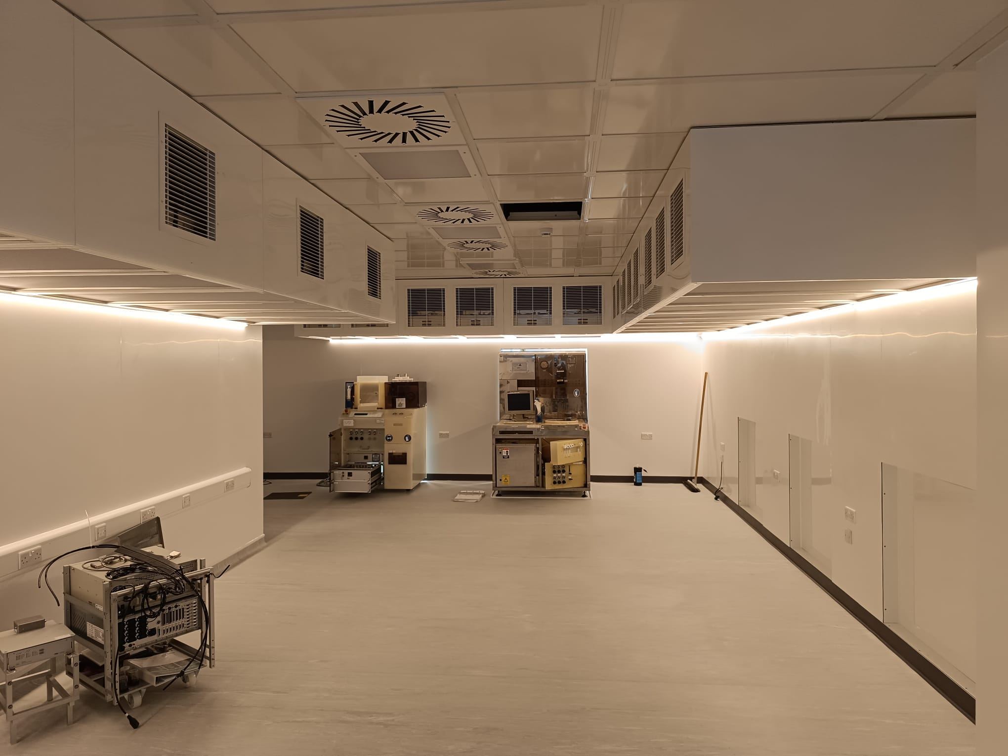Wide view of a cleanroom with LED panel lighting, ventilation grilles and wall-mounted small power
