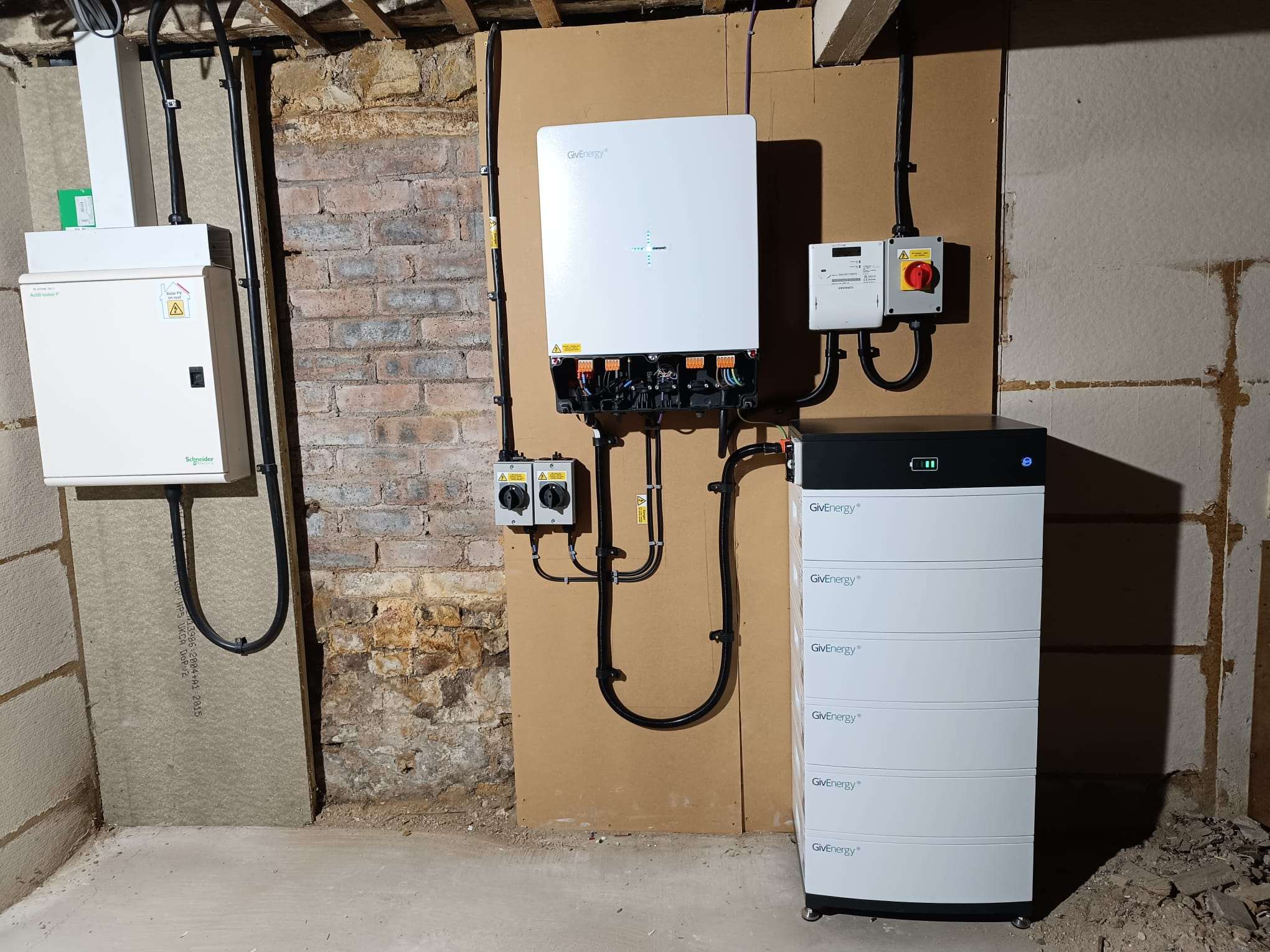 Hybrid inverter, isolators and a stacked battery installed in a Cupar plant room